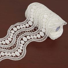 a roll of white lace sitting on top of a wooden table