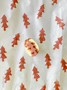 a piece of cake sitting on top of a white tablecloth covered in red trees