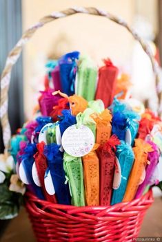 a basket filled with lots of different colored candy sticks in it's centerpiece