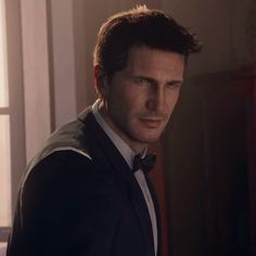 a man in a tuxedo and bow tie looking at the camera with an intense look on his face