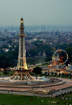 a tall tower with a clock on it's side in the middle of a park