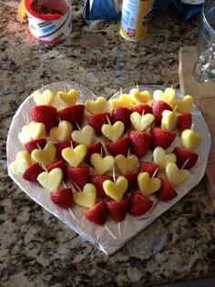 strawberries and apples arranged in the shape of hearts on a heart - shaped plate