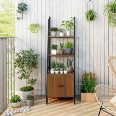 a wooden shelf filled with potted plants on top of a hard wood floor next to a white wall