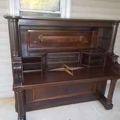 an old wooden desk in front of a window with a star on the bottom shelf