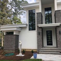 a white and gray house with black windows