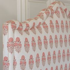 an upholstered headboard with pink and white floral designs on it's sides