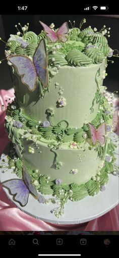 a three layer green cake with butterflies on it