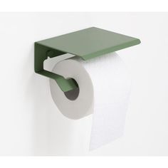 a roll of toilet paper is hanging on the wall next to a green towel holder