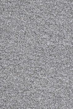 a close up view of a gray carpet with small speckles in the middle