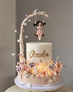 there is a cake with flowers on it and an angel figurine sitting on top