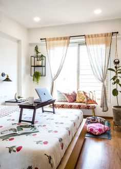 a bed room with a neatly made bed and a laptop