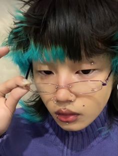 a person with blue hair and glasses holding their head in front of his eyeglasses