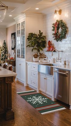 a kitchen decorated for christmas with wreaths and potted plants on the counter top