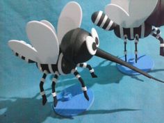 two black and white bee figurines are on blue surface with one facing the camera