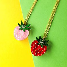 two necklaces that have strawberries on them