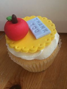 a yellow cupcake with an apple on top