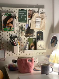 a white desk topped with a pink purse and lots of clutter on top of it