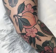 a close up of a person's leg with tattoos on it and flowers around the legs