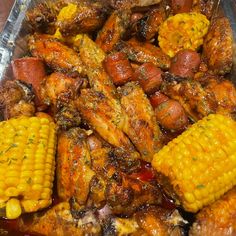 a tray filled with chicken and corn on the cob