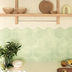 a kitchen counter with plates and bowls on top of it, next to a potted plant