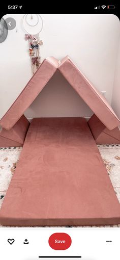 a pink dog bed in the corner of a room with a rug on top of it