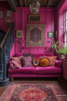 a living room with pink walls and rugs on the floor in front of a purple couch