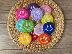 a basket filled with lots of different colored smiley face magnets on top of a wooden table