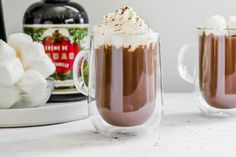 two glasses filled with hot chocolate and marshmallows