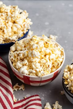 two bowls filled with popcorn on top of a table