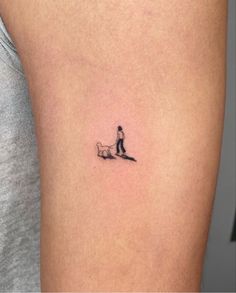 a small tattoo of a person walking a dog