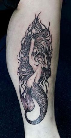 a woman's leg with a mermaid tattoo on it