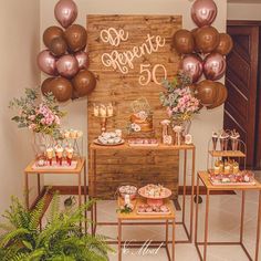 the dessert table is set up with pink and gold balloons