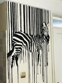 a zebra painted on the side of a wall next to a toilet paper dispenser