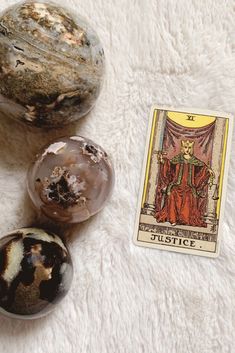 the tarot card is next to three marbles