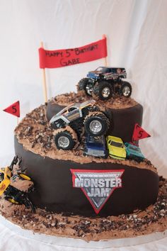 a birthday cake with monster jam trucks on top