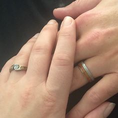 two people holding hands with rings on their fingers