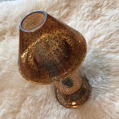 a gold vase sitting on top of a white rug