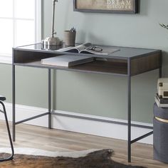 a desk with an open book on it in front of a window and a chair