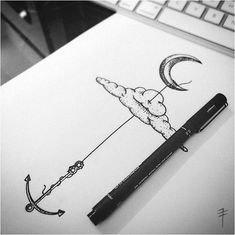 a pen is sitting on top of a paper with an anchor and moon drawn on it