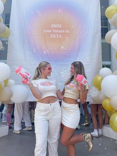 two women in white outfits standing next to each other