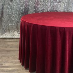 a round table with a red cloth on it in front of a sequin wall