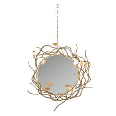 a round mirror hanging from a chain with leaves on it and branches in the foreground