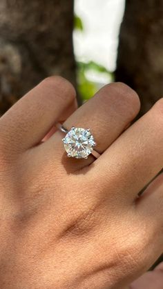 a woman's hand with a diamond ring on it