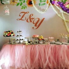 a table topped with lots of cake and desserts next to a wall that says e & y