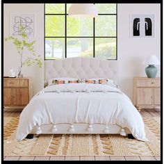 a white bed sitting in a bedroom next to a dresser and lamp on top of a rug