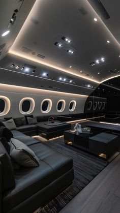 the interior of an airplane with lots of windows and leather couches in front of it