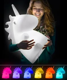 a woman holding a large white object in front of her face with multiple colors on it