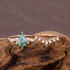 two rings on top of a piece of wood with diamonds and blue stones in the middle