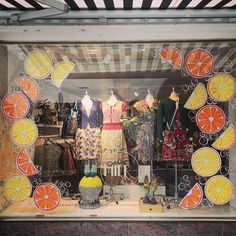 a display case with oranges and other clothing in it's glass front window