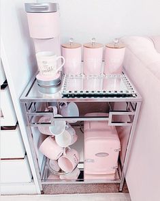 a shelf with cups, mugs and other items in it next to a couch